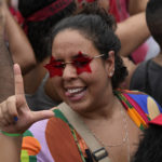 
              A supporter of Brazil's former President Luiz Inacio Lula da Silva, who is running for office again, flashes the letter L for "Lula" during a campaign rally with him in the Complexo do Alemao favela in Rio de Janeiro, Brazil, Wednesday, Oct. 12, 2022. The presidential run-off election is set for Oct. 30. (AP Photo/Silvia Izquierdo)
            