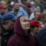 
              A woman looks up as she queues with others to receive a daily ration of bread, in a school in Mykolaiv, Tuesday, Oct. 25, 2022. Mykolaiv residents pick up bread from the only food distribution point in Varvarivka, a Mykolaiv district where thousands of people live. One person is allowed to receive free bread just once in three days. (AP Photo/Emilio Morenatti)
            