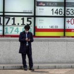 A person stands in front of an electronic stock board showing Japan's Nikkei 225 index and Japanese Yen/U.S. Dollar conversion rate at a securities firm Friday, Oct. 28, 2022, in Tokyo. Shares were mostly lower in Asia on Friday after a mixed session on Wall Street, where tech sector losses offset gains in other parts of the market. (AP Photo/Eugene Hoshiko)