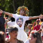 
              FILE - A man wearing a T-shirt featuring an image of Brazil's former President and now presidential candidate Luiz Inacio Lula da Silva, dances during a street block party in support of Lula, in Rio de Janeiro, Brazil, Sunday, Sept. 25, 2022. Brazil’s Oct. 2 presidential election is being contested by 11 candidates but only two stand a chance of reaching a runoff: da Silva and incumbent Jair Bolsonaro. (AP Photo/Silvia Izquierdo, File)
            