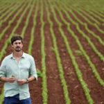 
              Joao Pedro walks in a soybean field at his Passatempo farm, Sidrolandia, Mato Grosso do Sul state, Brazil, Thursday, Oct. 20, 2022. President Jair Bolsonaro trusts his support among agribusiness leaders to help him win reelection later this month, while frontrunner Brazil's Former President Luiz Inacio Lula da Silva tries to make inroads with rural voters with a boost from defeated presidential candidate Sen. Simone Tebet, who is from the state of Mato Grosso do Sul. (AP Photo/Eraldo Peres)
            
