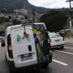 
              A van with the photo of Brazilian President Jair Bolsonaro, who is running for another term, drives on a street at the Rocinha favela during a presidential run-off election in Rio de Janeiro, Brazil, Sunday, Oct. 30, 2022. (AP Photo/Bruna Prado)
            