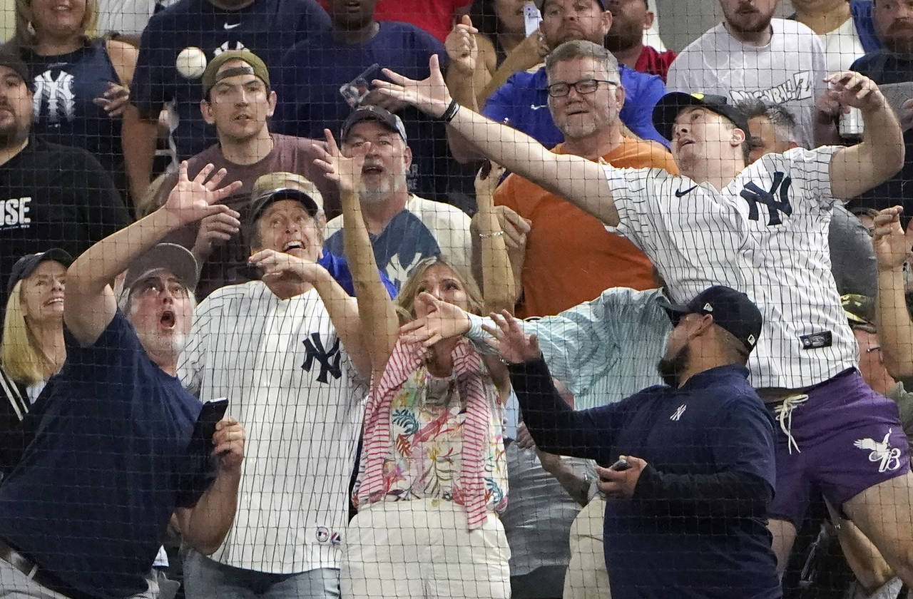 Fans reach for a foul ball by New York Yankees' Aaron Judge during the second inning in the second ...