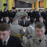 
              French President Emmanuel Macron, center, shares a lunch with cadets in a military school, Thursday, Oct. 27, 2022 in Bourges, south of Paris. French President Emmanuel Macron visits arms factory and a military school as France seeks to boost weapons production to face demand generated by Ukraine war. (AP Photo/Lewis Joly, Pool)
            