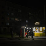 
              People stand outside a bar in Borodyanka, Kyiv region, Ukraine, Friday, Oct. 21, 2022. Russia has declared its intention to increase its targeting of Ukraine's power, water and other vital infrastructure in its latest phase of the nearly 8-month-old war. Ukrainian President Volodymyr Zelenskyy says that Moscow's forces have destroyed nearly a third of the country's power stations since Oct. 10. (AP Photo/Emilio Morenatti)
            