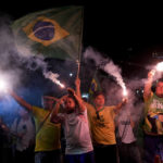 
              Supporters of Brazilian President Jair Bolsonaro hold flares after polls closed in the country's presidential run-off election, in Rio de Janeiro, Brazil, Sunday, Oct. 30, 2022. On Sunday, voters had to choose between incumbent Bolsonaro and his rival, former President Luiz Inacio Lula da Silva, after neither got enough support to win outright in the Oct. 2 general election. (AP Photo/Silvia Izquierdo)
            