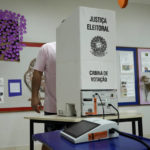 
              An electoral worker installs an electronic voting machine at a polling station in preparation for the presidential run-off election, in Brasilia, Brazil, Saturday, Oct. 29, 2022. On Sunday, Brazilians head to the voting booth again to choose between former President Luiz Inacio Lula da Silva and incumbent Jair Bolsonaro, who are facing each other in a runoff vote after neither got enough support to win outright in the Oct. 2 general election.  (AP Photo/Eraldo Peres)
            