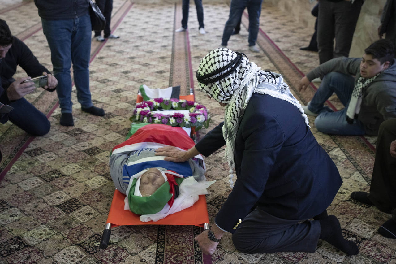 FILE - Mourners take a last look at the body of Omar Asaad, 78, during his funeral at a mosque in t...