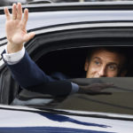 
              French President Emmanuel Macron waves as he leaves in a car after a visit for the commemorative century exposition of the opening of the Grande Mosque of Paris, in Paris, Wednesday Oct. 19, 2022. (Ludovic Marin/Pool via AP)
            
