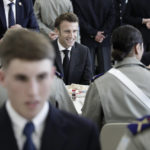 
              French President Emmanuel Macron, center, shares a lunch with cadets in a military school, Thursday, Oct. 27, 2022 in Bourges, south of Paris. French President Emmanuel Macron visits arms factory and a military school as France seeks to boost weapons production to face demand generated by Ukraine war. (AP Photo/Lewis Joly, Pool)
            