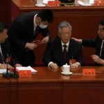 
              Chinese President Xi Jinping at left looks on as former Chinese President Hu Jintao is assisted to leave the hall during the closing ceremony of the 20th National Congress of China's ruling Communist Party at the Great Hall of the People in Beijing, Saturday, Oct. 22, 2022. Former Chinese President Hu Jintao, Xi's predecessor as party leader, was helped off the stage shortly after foreign media came in, sparking speculation about his health. (AP Photo/Ng Han Guan)
            