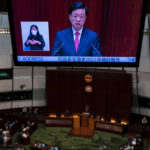 
              A video screen shows Hong Kong Chief Executive John Lee as he delivers his policy address at the chamber of the Legislative Council in Hong Kong, Wednesday, Oct. 19, 2022. Hong Kong's leader on Wednesday unveiled a new visa scheme to woo global talent, as the city seeks to stem a brain drain that has risked its status as an international financial center. (AP Photo/Vernon Yuen)
            