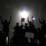 
              FILE - Protesters raise their hands in front of a line of police officers during a rally in Las Vegas on June 1, 2020. Several protesters and self-described "legal observers" filed a federal civil rights lawsuit against Las Vegas police. They claim excessive force and free speech violations during racial justice demonstrations following the death of a Black man in police custody in Minneapolis. (AP Photo/John Locher, File)
            