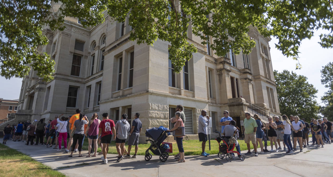 FILE - A long line of voters wraps around the Sedgwick County Historic Courthouse in Wichita, Kan.,...