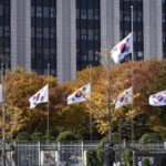 
              South Korean national flags fly at half-mast at the government complex in Seoul, South Korea, Sunday, Oct. 30, 2022. A mass of mostly young people celebrating Halloween festivities in Seoul became trapped and crushed as the crowd surged into a narrow alley, killing dozens of people and injuring dozens of others in South Korea's worst disaster in years. (AP Photo/Lee Jin-man)
            