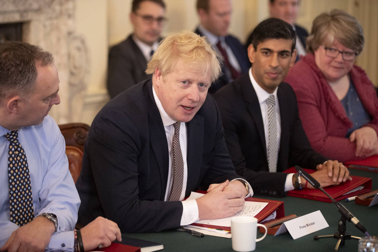 FILE - British Prime Minister Boris Johnson speaks during his first Cabinet meeting flanked by his ...