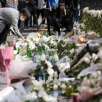 
              A mourner places flower to pay tribute to victims of a deadly accident following Saturday night's Halloween festivities on the street near the scene in Seoul, South Korea, Monday, Oct. 31, 2022. Police are investigating what caused a crowd surge that killed more than 150 people during Halloween festivities in Seoul over the weekend in the country’s worst disasters in years. (AP Photo/Lee Jin-man)
            