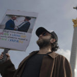 
              Ukraine's Iranian community member holds a banner with a picture of Russian President Vladimir Putin, left, and  Iran’s Supreme Leader Ayatollah Ali Khamenei shaking hands, during a protest against the Russian and Iranian regimes in Kyiv, Ukraine, Friday, Oct. 28, 2022. (AP Photo/Andrew Kravchenko).
            