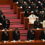 
              Attendees bow their heads to observe a moment of silence for fallen comrades during the opening ceremony of the 20th National Congress of China's ruling Communist Party held at the Great Hall of the People in Beijing, China, Sunday, Oct. 16, 2022. China on Sunday opens a twice-a-decade party conference at which leader Xi Jinping is expected to receive a third five-year term that breaks with recent precedent and establishes himself as arguably the most powerful Chinese politician since Mao Zedong. (AP Photo/Mark Schiefelbein)
            