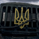 
              A Ukrainian national emblem is displayed on a military truck near Bakhmut, Donetsk region, Ukraine, Saturday, Oct. 22, 2022. (AP Photo/LIBKOS)
            