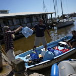 
              Members of the boating community help each other out by ferrying supplies include water and fuel, following the passage of Hurricane Ian, on San Carlos Island in Fort Myers Beach, Fla., Friday, Oct. 7, 2022. (AP Photo/Rebecca Blackwell)
            