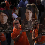 
              Supporters of Lebanese President Michel Aoun hold his portraits as he delivers a speech outside the presidential palace in Baabda, east of Beirut, Lebanon, Sunday, Oct. 30, 2022. Aoun left Lebanon's presidential palace Sunday marking the end of his six-year term without a replacement, leaving the small nation in a political vacuum that is likely to worsen its historic economic meltdown. (AP Photo/Bilal Hussein)
            