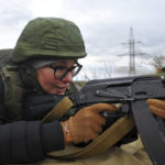 
              A woman prepares to fire from a Kalashnikov assault rifle at short-term courses where everyone can be able to receive military skills during theoretical and practical training is provided at a military range in Rostov-on-Don region, southern Russia, Friday, Oct. 21, 2022. (AP Photo)
            