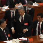 
              Former Chinese President Hu Jintao, center, is helped during the closing ceremony of the 20th National Congress of China's ruling Communist Party at the Great Hall of the People in Beijing, Saturday, Oct. 22, 2022. (AP Photo/Andy Wong)
            