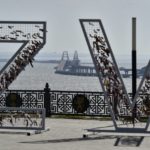 
              A helicopter dropping water to stop fire on Crimean Bridge connecting Russian mainland and Crimean peninsula over the Kerch Strait, is seen through the letters Z and V, which have become a symbol of the Russian military, in Kerch, Crimea, Saturday, Oct. 8, 2022. Russian authorities say a truck bomb has caused a fire and the collapse of a section of a bridge linking Russia-annexed Crimea with Russia. The bridge is a key supply artery for Moscow's faltering war effort in southern Ukraine. (AP Photo)
            