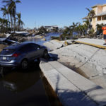 
              CORRECTS DATELINE TO MATLACHA, FLA., INSTEAD OF SPRING HILL - A man takes pictures of the destruction around the bridge leading to Pine Island, in the aftermath of Hurricane Ian in Matlacha, Fla., Sunday, Oct. 2, 2022. The only bridge to the island is heavily damaged so it can only be reached by boat or air. (AP Photo/Gerald Herbert)
            