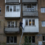 
              A man repairs his balcony on a building damaged by fighting between Ukrainian and Russian forces in Borodyanka, Kyiv region, Ukraine, Thursday, Oct. 20, 2022. Airstrikes cut power and water supplies to hundreds of thousands of Ukrainians on Tuesday, part of what the country's president called an expanding Russian campaign to drive the nation into the cold and dark and make peace talks impossible. (AP Photo/Emilio Morenatti)
            