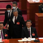 
              Former President Hu Jintao walks past Chinese President Xi Jinping, right, and Premier Li Keqiang during the closing ceremony of the 20th National Congress of China's ruling Communist Party at the Great Hall of the People in Beijing, Saturday, Oct. 22, 2022. (AP Photo/Ng Han Guan)
            