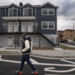 
              Dexter Davis, a neighborhood resident, walks the street alongside a recently built home elevated to protect against floodwaters 10 years after the area was severely damaged by Superstorm Sandy, Wednesday, Oct. 19, 2022, in the Edgemere neighborhood of the Queens borough of New York. There are no skateparks in Edgemere. No coffee shops. In fact, said Davis, a former NYC police officer, laments that there are few places for young people to go. "The things that they pump into the other communities around us are more positive (AP Photo/John Minchillo)
            