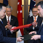 
              Prime Minister of Singapore Lee Hsien Loong, second left, and Australian Prime Minister Anthony Albanese, second right, observe the exchange of a Memorandum of Understanding, linked to the Singapore-Australia Green Economy Agreement, between Austrade CEO Xavier Simonet, right, and CEO of Enterprise Singapore Png Cheon at Parliament House in Canberra, Tuesday, Oct. 18, 2022. Lee on a 2-day visit to Canberra. (Lukas Coch/Pool via AP)
            