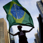 
              Ana Luiza Grace, supporter of Brazil's former President Luiz Inacio Lula da Silva, who is running for president again, holds a Brazilian flag after the closing of the polls for a presidential run-off election in Sao Paulo, Brazil, Sunday, Oct. 30, 2022.(AP Photo/Matias Delacroix)
            
