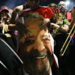 
              A supporter of former Brazilian President Luiz Inacio Lula da Silva holds a flag emblazoned with da Silva's face after results in the presidential run-off election were announced, in Sao Paulo, Brazil, Sunday, Oct. 30, 2022. Brazil's electoral authority said that da Silva defeated incumbent Jair Bolsonaro to become the country's next president. (AP Photo/Matias Delacroix)
            
