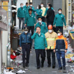
              South Korean President Yoon Suk Yeol, center left, visits the scene where dozens of people died and were injured in Seoul, South Korea, Sunday, Oct. 30, 2022, after a mass of mostly young people celebrating Halloween festivities became trapped and crushed as the crowd surged into a narrow alley. (Han Sang-gyun/Yonhap via AP)
            