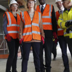 
              Britain's Prime Minister Liz Truss, foreground and Chancellor of the Exchequer Kwasi Kwarteng pose for a photo, during a visit to a construction site for a medical innovation campus, on day three of the Conservative Party annual conference at the International Convention Centre in Birmingham, England, Tuesday, Oct. 4, 2022. (Stefan Rousseau/Pool Photo via AP)
            