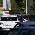 
              A police officer directs cars as drivers line up in a gas station in Paris, Tuesday, Oct.11, 2022. Shortages which the government says are largely caused by strikes that have hit French fuel refineries are making life difficult for drivers in the Paris region and elsewhere. (AP Photo/Christophe Ena)
            