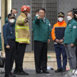 
              South Korean President Yoon Suk Yeol, center, is briefed at the scene where dozens of people died and were injured in Seoul, South Korea, Sunday, Oct. 30, 2022, after a mass of mostly young people celebrating Halloween festivities became trapped and crushed as the crowd surged into a narrow alley.  (AP Photo/Lee Jin-man)
            