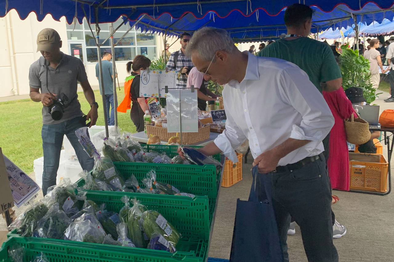 U.S. Ambassador to Japan Rahm Emanuel looks at vegetables at the farmers market at Camp Hansen, a U...