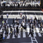 
              FILE - Visitors wearing protective masks to help curb the spread of the coronavirus walk at pedestrian crossings in Tokyo on Sept. 20, 2021. Japan has stepped up its push to catch up on digitization by telling a reluctant public they have to sign up for digital IDs or possibly lose access to their public health insurance. (AP Photo/Eugene Hoshiko, File)
            