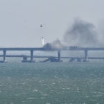 
              A helicopter drops water to stop fire on Crimean Bridge connecting Russian mainland and Crimean peninsula over the Kerch Strait, in Kerch, Crimea, Saturday, Oct. 8, 2022. Russian authorities say a truck bomb has caused a fire and the collapse of a section of a bridge linking Russia-annexed Crimea with Russia. The bridge is a key supply artery for Moscow's faltering war effort in southern Ukraine. (AP Photo)
            