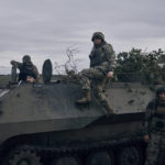 
              Ukrainian servicemen and a servicewoman, center, pose for a photo with their armored vehicle near Bakhmut, Donetsk region, Ukraine, Saturday, Oct. 22, 2022. (AP Photo/LIBKOS)
            