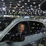 
              FILE - President Joe Biden drives a Cadillac Lyriq through the showroom during a tour at the Detroit Auto Show, Sept. 14, 2022, in Detroit. Americans are generally more likely to support than oppose many of the government actions on climate change included in the law, a new poll by The Associated Press-NORC Center for Public Affairs Research shows. That includes incentives for electric vehicles and solar panels, though relatively few say they are inclined to pursue either in the next three years. (AP Photo/Evan Vucci, File)
            