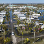 
              Water floods a damaged trailer park in Fort Myers, Fla., on Saturday, Oct. 1, 2022, after Hurricane Ian passed by the area. (AP Photo/Steve Helber)
            