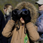 
              An observer uses binoculars to see Andean condors flying in the Sierra Paileman where the Andean Condor conservation program is located in the Rio Negro province of Argentina, Thursday, Oct. 13, 2022, the day before the release of two born in captivity almost three years prior. For 30 years the program has hatched chicks in captivity, rehabilitated others and freed them across South America. (AP Photo/Natacha Pisarenko)
            