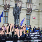 
              Protestors hold EU flags and banners as they demonstrate outside of an EU Summit at Prague Castle in Prague, Czech Republic, Friday, Oct 7, 2022. European Union leaders converged on Prague Castle Friday to try to bridge significant differences over a natural gas price cap as winter approaches and Russia's war on Ukraine fuels a major energy crisis. Sign reads "No Veto". (AP Photo/Petr David Josek)
            