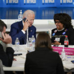 
              President Joe Biden works the phones during a grassroots volunteer event with the Oregon Democrats at the SEIU Local 49 in Portland, Ore. Friday, Oct. 14, 2022. Rosa Colquitt, Vice Chair Democratic Party of Oregon, is seated at right. (AP Photo/Carolyn Kaster)
            