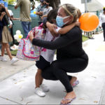 
              FILE - Carol Basilio, right, hugs her daughter Giovanna outside of iPrep Academy on the first day of school, in Miami, Aug. 23, 2021. In interviews with The Associated Press, close to 50 school leaders, teachers, parents and health officials reflected on decisions to keep students in extended online learning, especially during the spring semester of 2021. (AP Photo/Lynne Sladky, File)
            